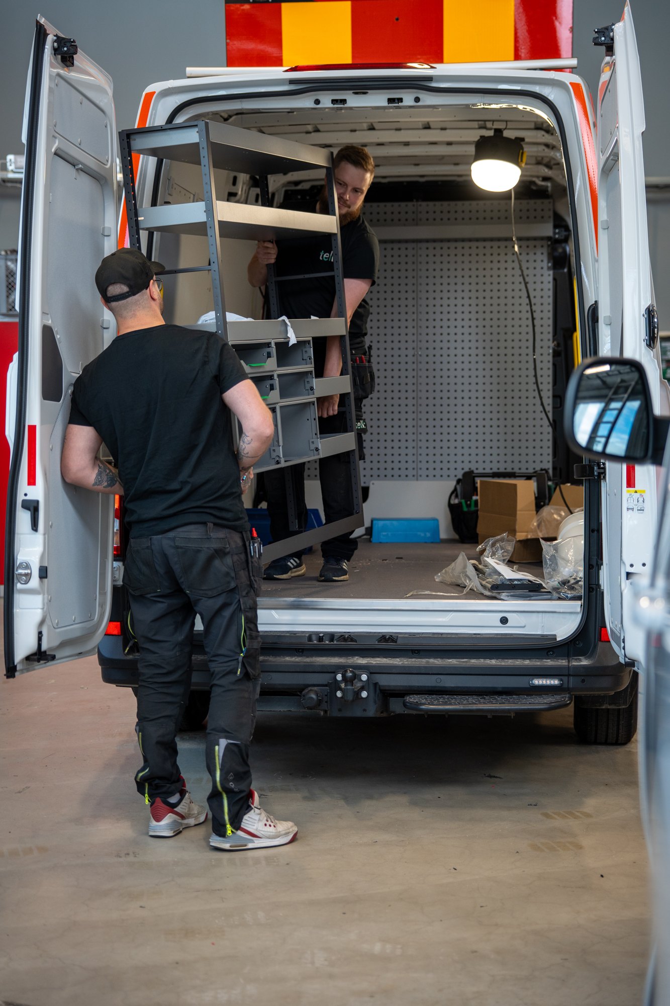 Servicefordon med öppna bakdörrar under installationsarbete
